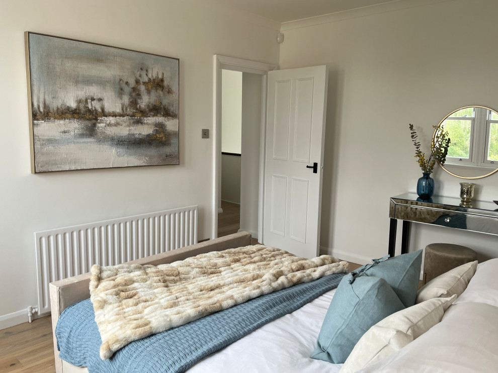 Großes Modernes Schlafzimmer mit weißer Wandfarbe und hellem Holzboden in London