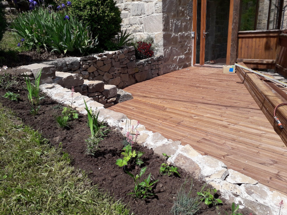 Mid-sized country courtyard and ground level deck in Saint-Etienne with with dock, no cover and wood railing.