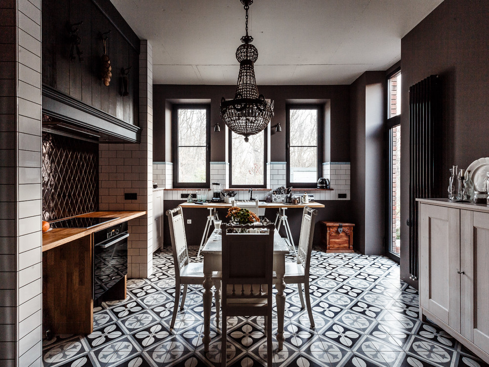Inspiration for an eclectic u-shaped eat-in kitchen in Other with a farmhouse sink, open cabinets, white cabinets, wood benchtops, ceramic floors and black appliances.