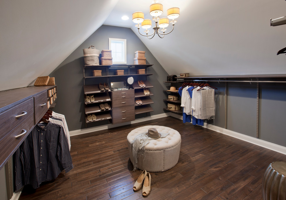 This is an example of a traditional gender-neutral dressing room in Boston with flat-panel cabinets, dark wood cabinets and dark hardwood floors.