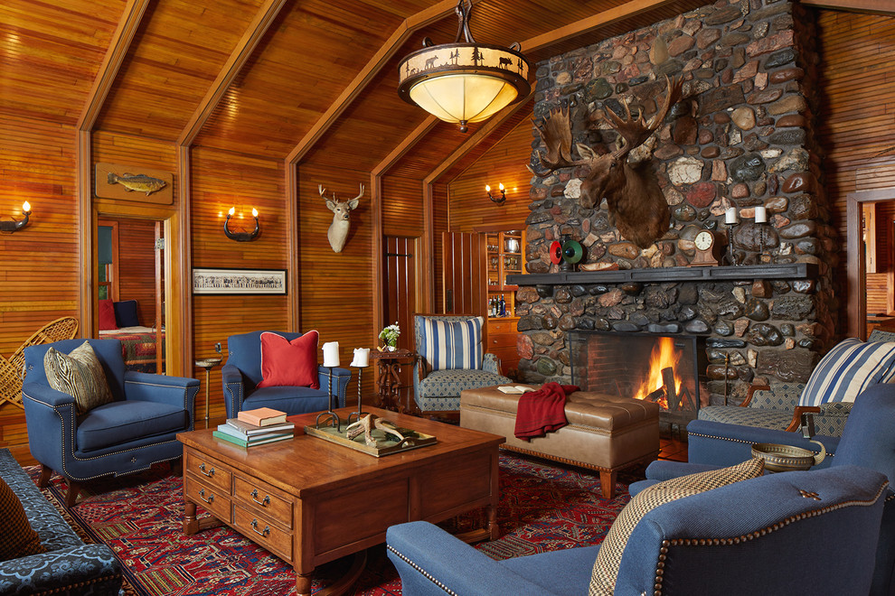 Photo of a mid-sized country formal open concept living room in Minneapolis with a standard fireplace, a stone fireplace surround, brown walls, carpet, no tv and red floor.
