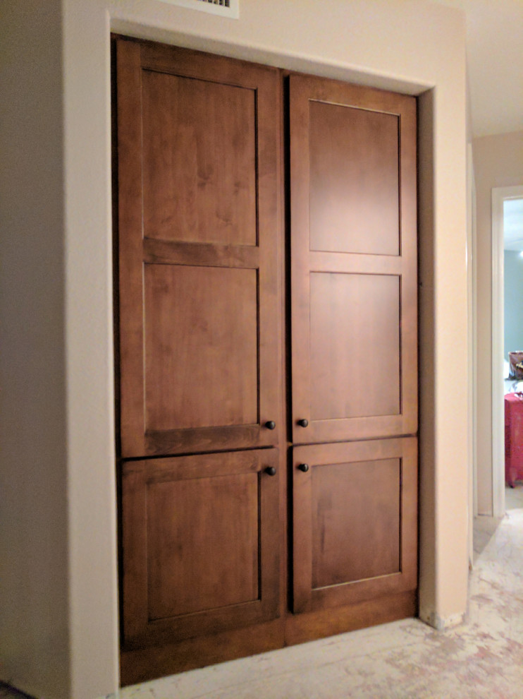 Example of a large arts and crafts carpeted and white floor built-in closet design in Nashville with recessed-panel cabinets and medium tone wood cabinets