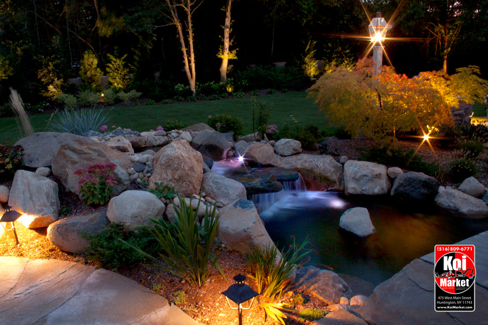 This is an example of a traditional backyard garden in New York with a water feature.