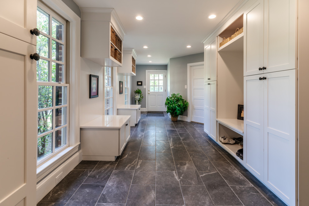 This is an example of a mid-sized contemporary mudroom in DC Metro with grey walls, a white front door and grey floor.