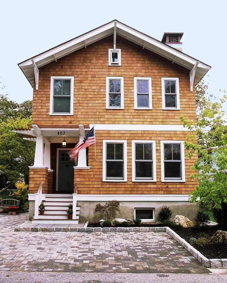 Mid-sized arts and crafts two-storey brown house exterior in New York with wood siding, a gable roof and a shingle roof.