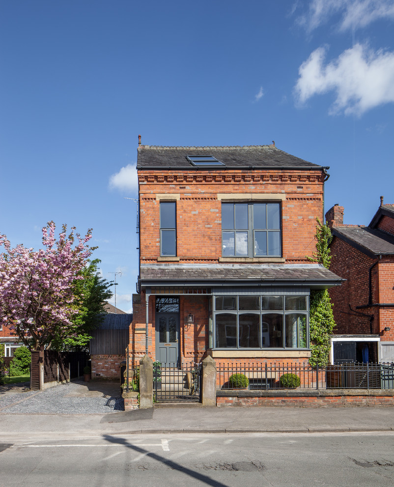 Inspiration for a mid-sized transitional two-storey brick red house exterior in Manchester.