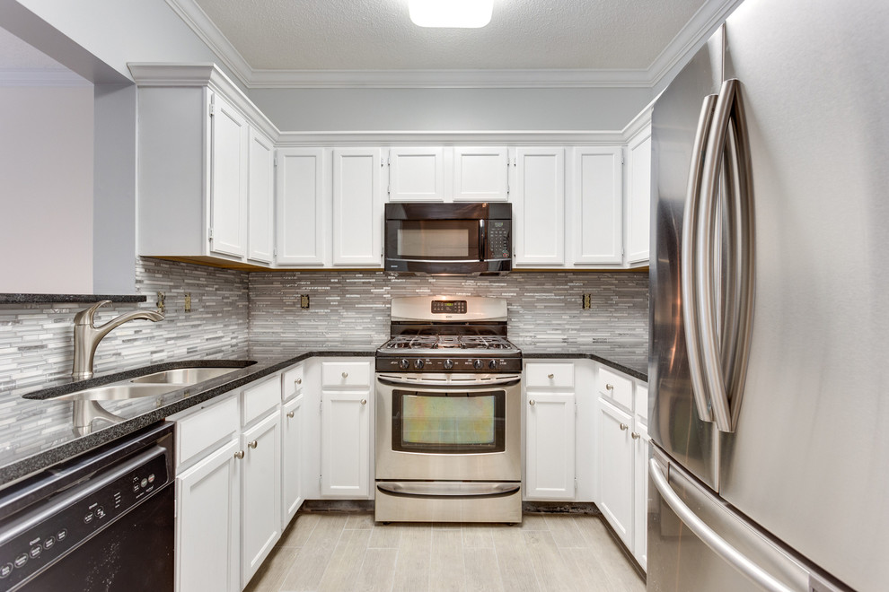 Inspiration for a mid-sized contemporary u-shaped kitchen in DC Metro with a double-bowl sink, shaker cabinets, white cabinets, grey splashback, matchstick tile splashback, stainless steel appliances, light hardwood floors and no island.