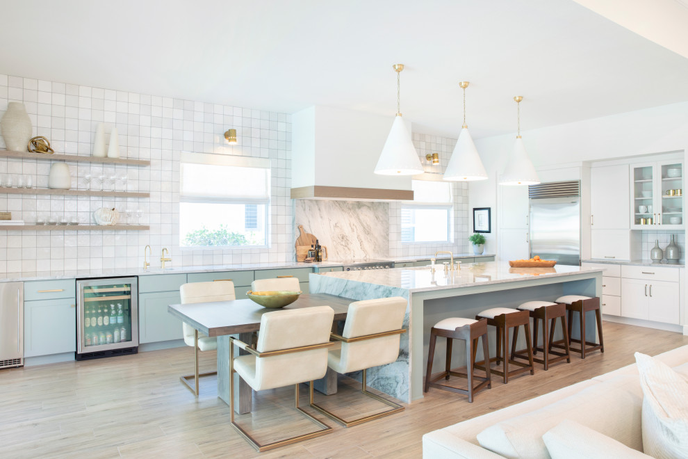 This is an example of a large beach style l-shaped eat-in kitchen in Miami with a single-bowl sink, shaker cabinets, green cabinets, quartzite benchtops, multi-coloured splashback, stone slab splashback, stainless steel appliances, porcelain floors, with island, grey floor and multi-coloured benchtop.