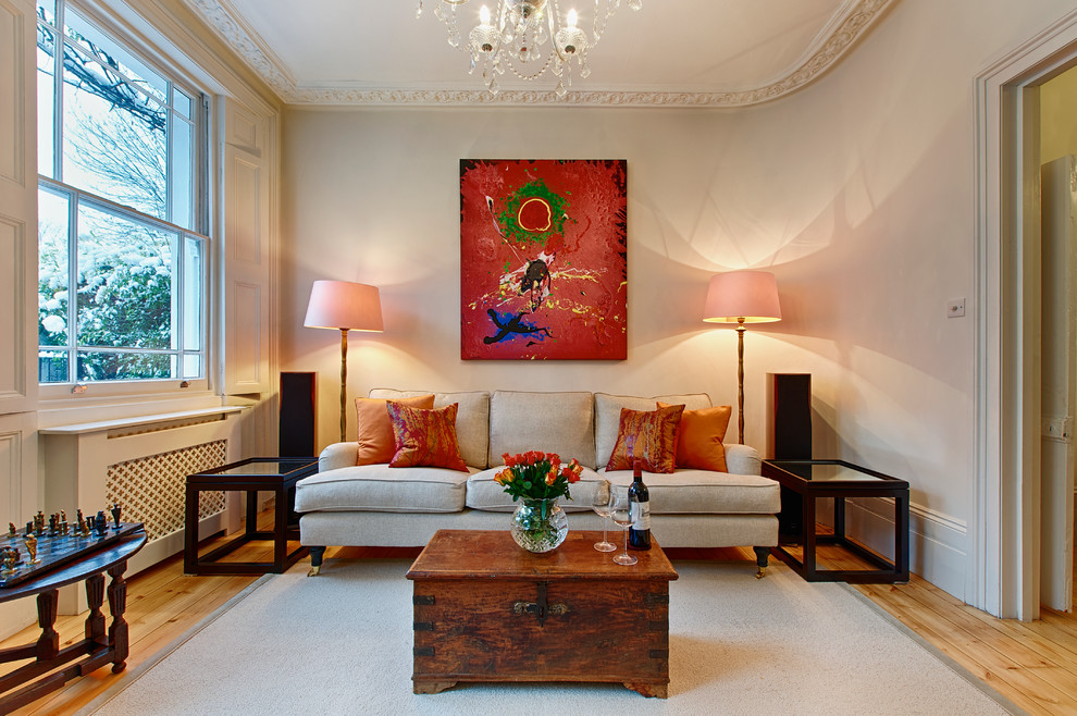 Inspiration for a mid-sized traditional enclosed living room in London with white walls and light hardwood floors.