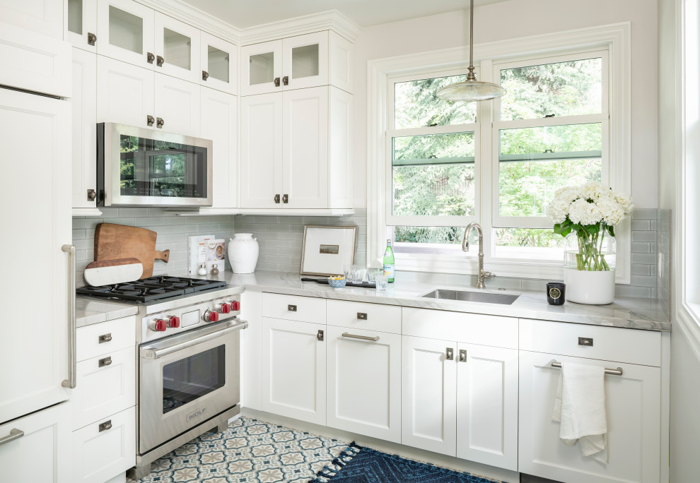 Mid-sized transitional l-shaped separate kitchen in Salt Lake City with an undermount sink, shaker cabinets, white cabinets, grey splashback, no island, multi-coloured floor, grey benchtop, marble benchtops, subway tile splashback, panelled appliances and cement tiles.