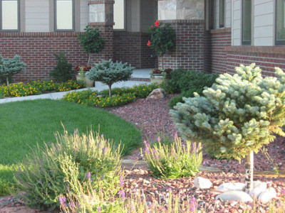 Photo of a mid-sized full sun front yard stone driveway in Omaha.