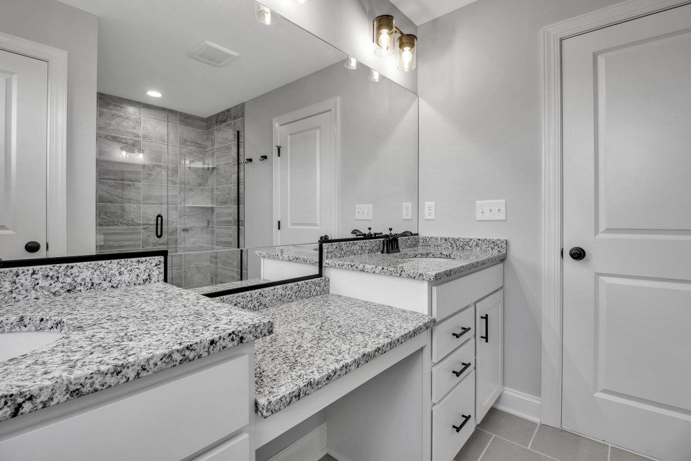 Modernes Badezimmer En Suite mit flächenbündigen Schrankfronten, weißen Schränken, grauen Fliesen, grauer Wandfarbe, grauem Boden, Doppelwaschbecken und eingebautem Waschtisch in New York
