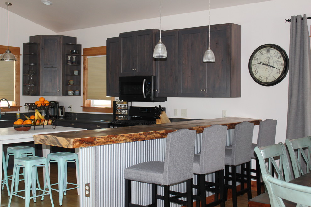 Inspiration for a large transitional u-shaped light wood floor and brown floor open concept kitchen remodel with shaker cabinets, dark wood cabinets, an island and black countertops