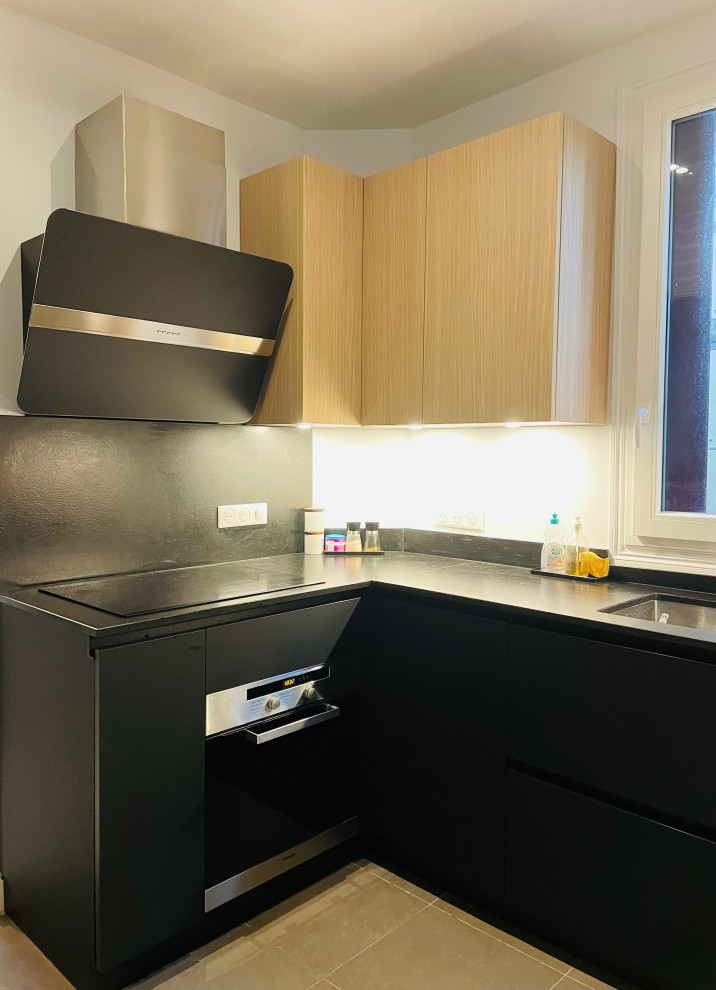 Photo of a medium sized contemporary u-shaped kitchen/diner in Paris with an integrated sink, beaded cabinets, light wood cabinets, granite worktops, granite splashback, black appliances, ceramic flooring, an island, grey floors and black worktops.
