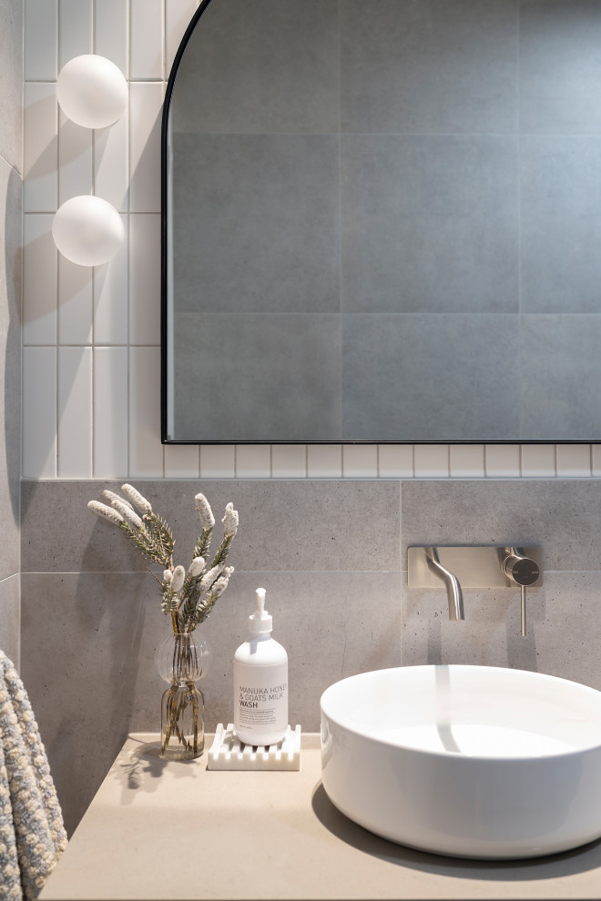 Photo of a mid-sized modern bathroom in Canberra - Queanbeyan with furniture-like cabinets, an open shower, a one-piece toilet, gray tile, subway tile, grey walls, porcelain floors, a vessel sink, engineered quartz benchtops, grey floor, a hinged shower door, grey benchtops, a single vanity and a floating vanity.
