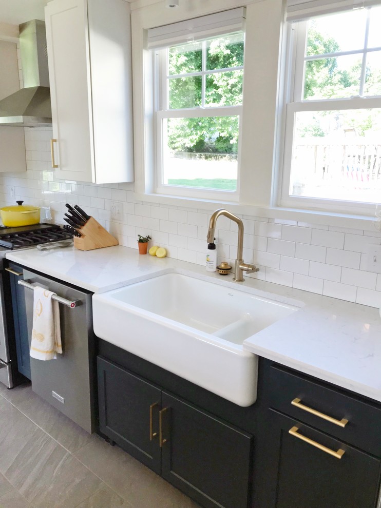Transitional gray floor kitchen photo with a farmhouse sink, quartz countertops and stainless steel appliances