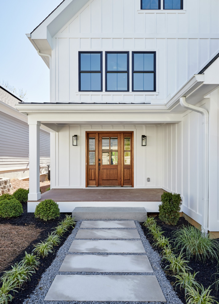 This is an example of a large country front door in Cincinnati with white walls, a single front door, a medium wood front door and wood.