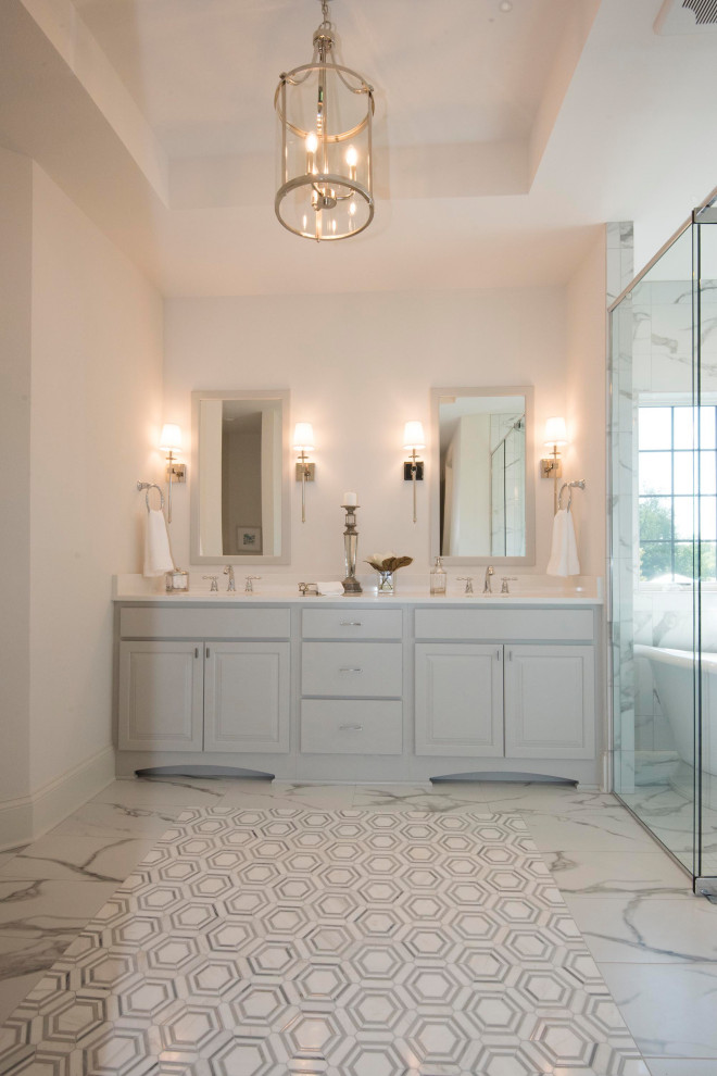 Large transitional master wet room bathroom in Milwaukee with raised-panel cabinets, white cabinets, a freestanding tub, multi-coloured tile, marble, white walls, marble floors, an undermount sink, engineered quartz benchtops, multi-coloured floor, a hinged shower door and white benchtops.