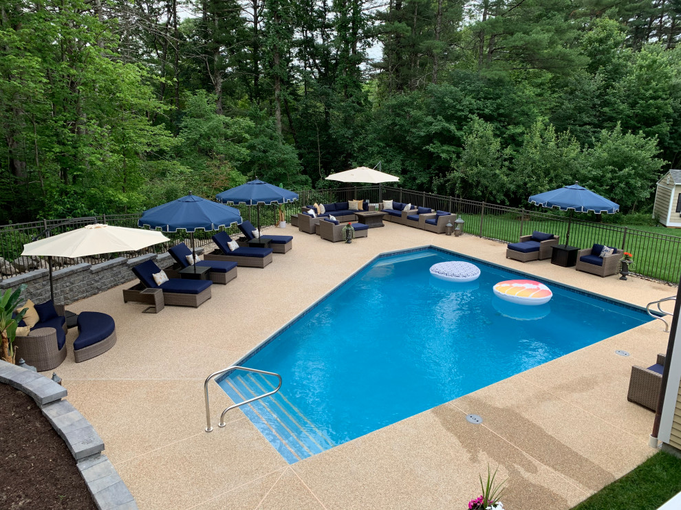 Photo of a large transitional backyard custom-shaped pool in Boston with with privacy feature and decking.