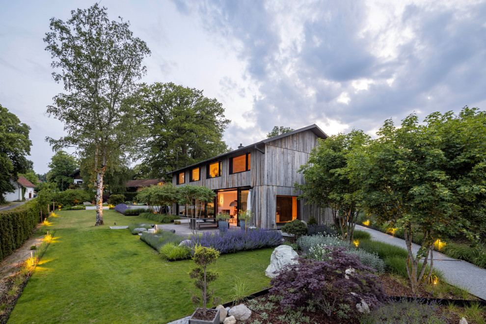 Стильный дизайн: большой, двухэтажный, деревянный, серый частный загородный дом в современном стиле с двускатной крышей, черепичной крышей, серой крышей и отделкой планкеном - последний тренд