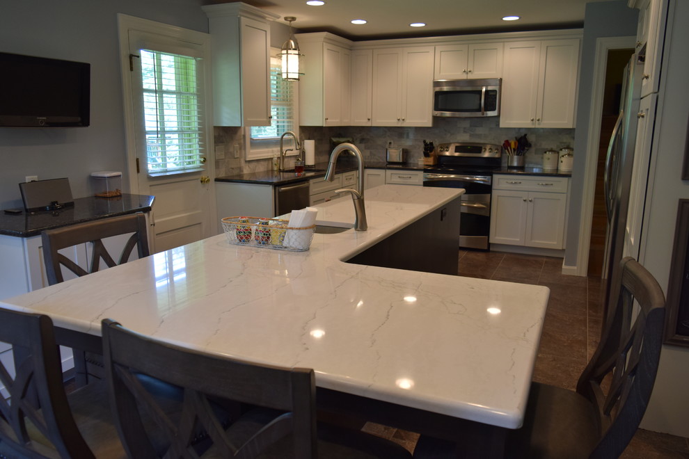 Large elegant l-shaped terra-cotta tile kitchen photo with shaker cabinets, white cabinets, quartz countertops, blue backsplash, porcelain backsplash, stainless steel appliances and an island