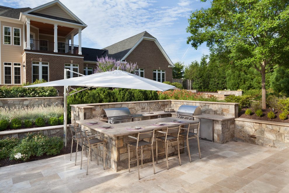 Inspiration for a large traditional backyard patio in DC Metro with natural stone pavers.