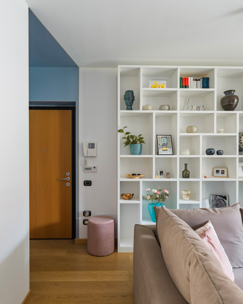 Свежая идея для дизайна: открытая гостиная комната среднего размера в современном стиле с с книжными шкафами и полками, белыми стенами, светлым паркетным полом, мультимедийным центром и бежевым полом - отличное фото интерьера