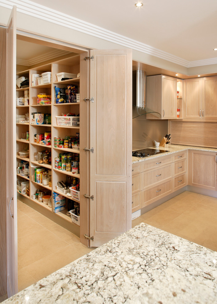 Photo of an expansive contemporary u-shaped kitchen pantry in Sydney with an undermount sink, recessed-panel cabinets, light wood cabinets, granite benchtops, brown splashback, glass sheet splashback, stainless steel appliances and travertine floors.