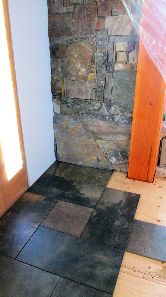 Front door - rustic slate floor and multicolored floor front door idea with white walls and a light wood front door