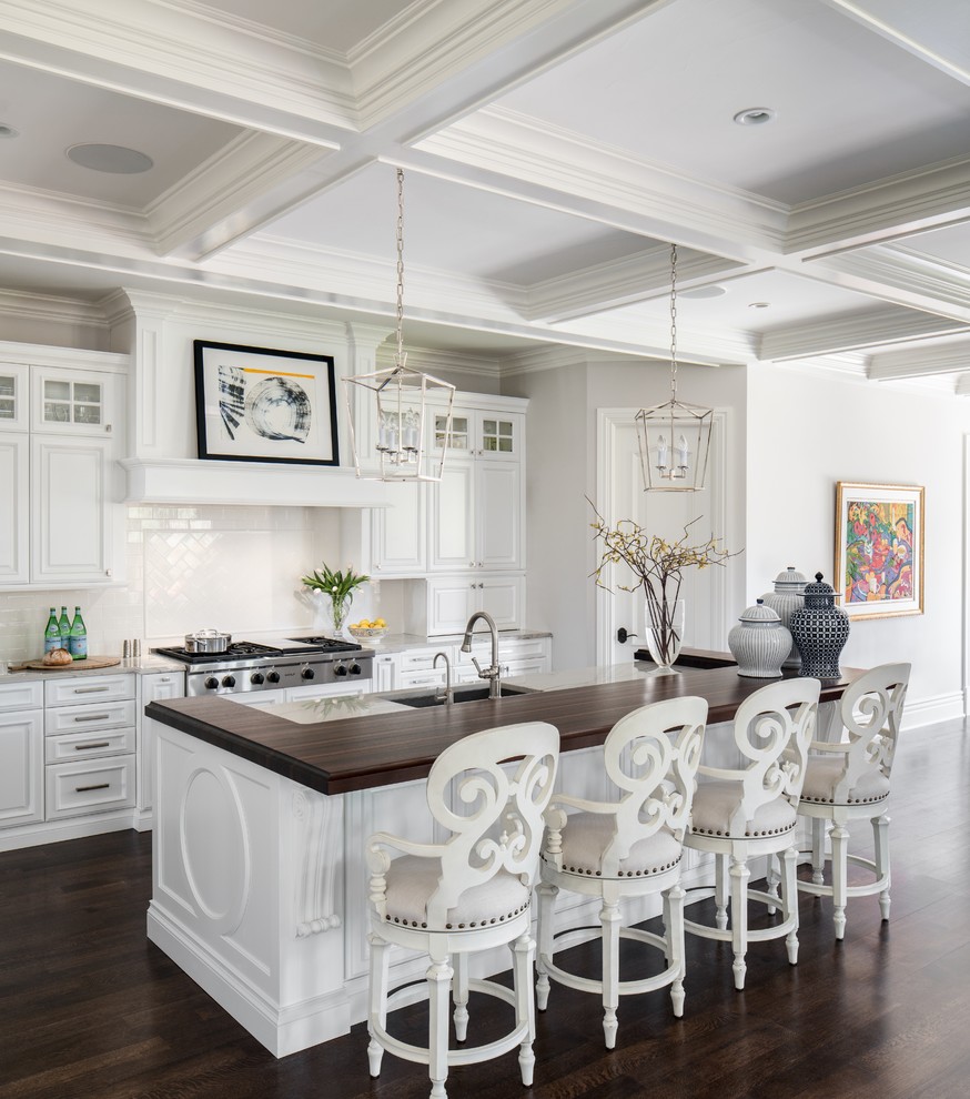 Design ideas for a traditional kitchen in Denver with raised-panel cabinets, white cabinets, white splashback, ceramic splashback, stainless steel appliances, dark hardwood floors, with island and marble benchtops.