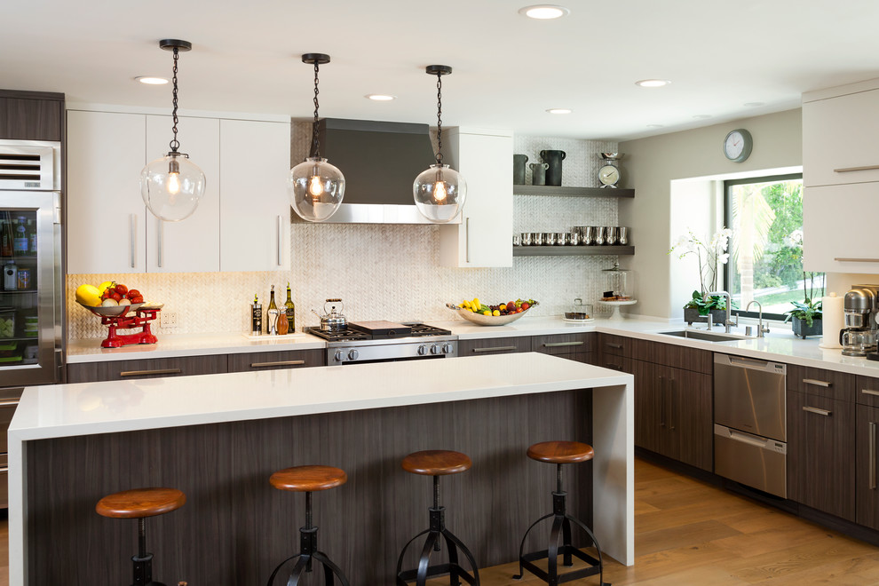 Photo of a large contemporary u-shaped eat-in kitchen in Los Angeles with flat-panel cabinets, dark wood cabinets, white splashback, medium hardwood floors, with island, an undermount sink, quartz benchtops, ceramic splashback and stainless steel appliances.