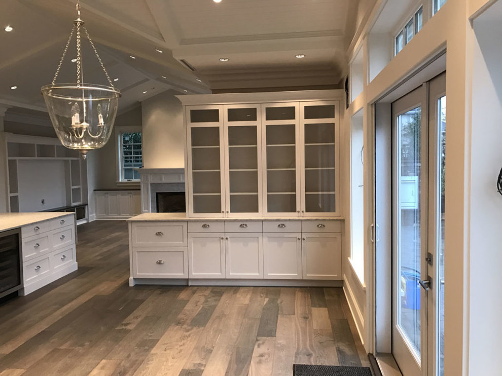 Beach style l-shaped open plan kitchen in Vancouver with a drop-in sink, shaker cabinets, white cabinets, quartz benchtops, grey splashback, stainless steel appliances, with island and beige floor.