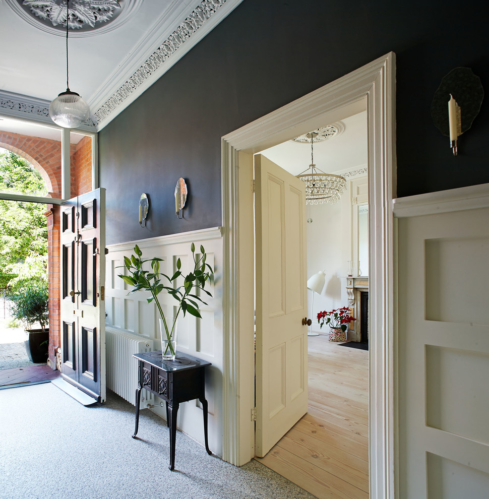 Photo of a mid-sized traditional entry hall in Dublin with grey walls, granite floors and a black front door.