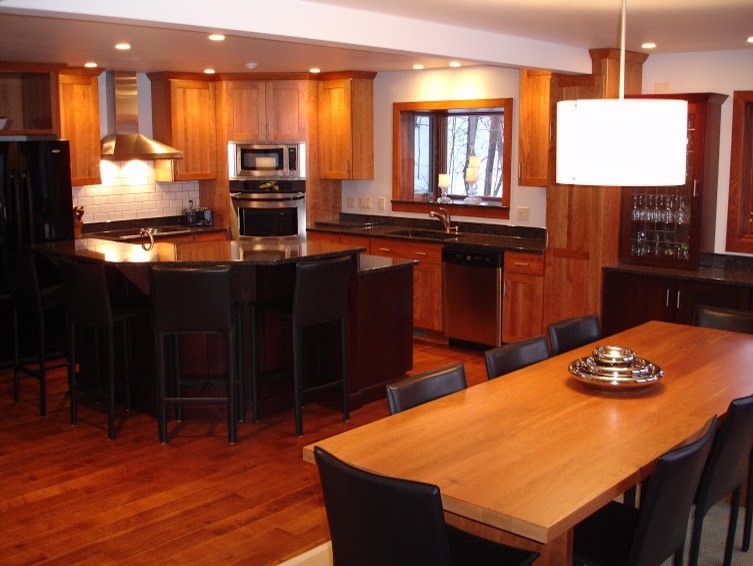 Inspiration for a large modern l-shaped light wood floor eat-in kitchen remodel with an undermount sink, flat-panel cabinets, light wood cabinets, quartz countertops, gray backsplash, stone tile backsplash, stainless steel appliances and an island