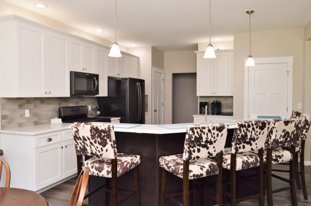 Open concept kitchen - mid-sized transitional single-wall open concept kitchen idea with a drop-in sink, shaker cabinets, white cabinets, quartzite countertops, beige backsplash, stainless steel appliances, an island and white countertops