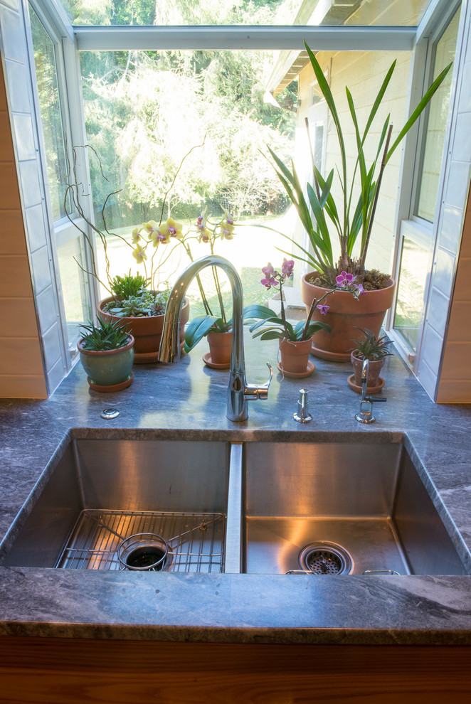Mid-sized transitional u-shaped medium tone wood floor eat-in kitchen photo with an undermount sink, flat-panel cabinets, medium tone wood cabinets, quartzite countertops, white backsplash, ceramic backsplash, stainless steel appliances and an island