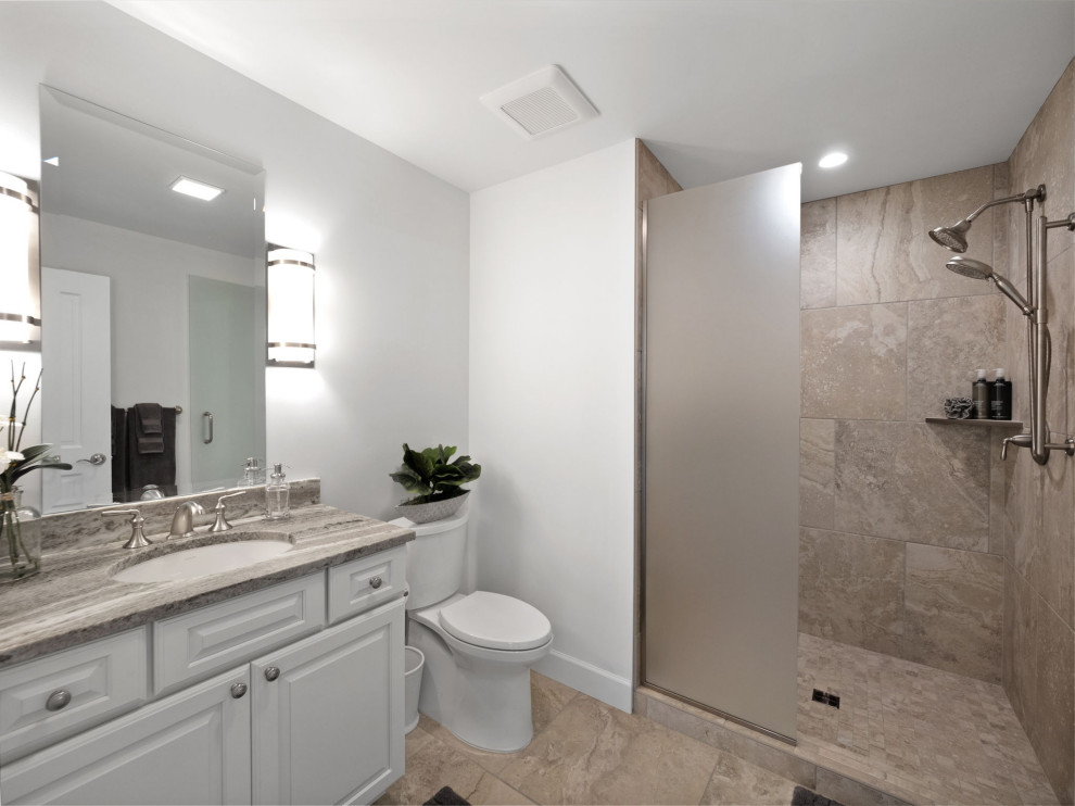 Klassisk inredning av ett mellanstort flerfärgad flerfärgat badrum, med luckor med upphöjd panel, vita skåp, en kantlös dusch, en toalettstol med separat cisternkåpa, brun kakel, keramikplattor, vita väggar, klinkergolv i keramik, ett undermonterad handfat, bänkskiva i kvarts, brunt golv och med dusch som är öppen