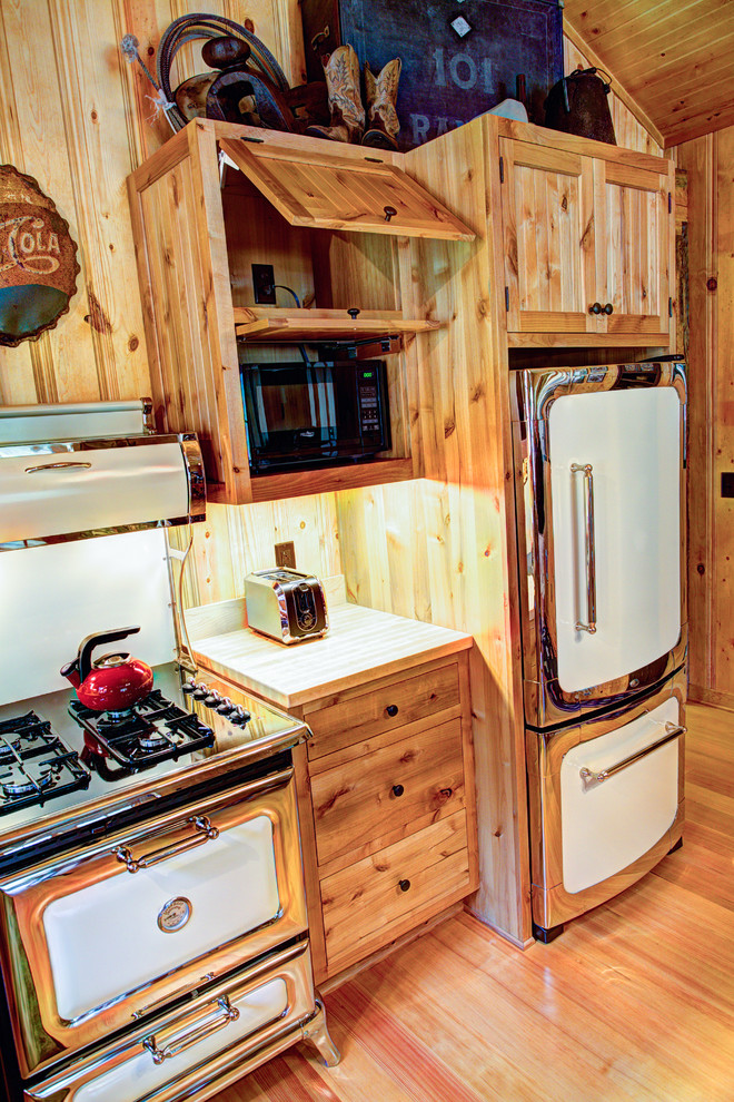 Mid-sized mountain style l-shaped light wood floor eat-in kitchen photo with a farmhouse sink, beaded inset cabinets, light wood cabinets, wood countertops, stainless steel appliances and no island