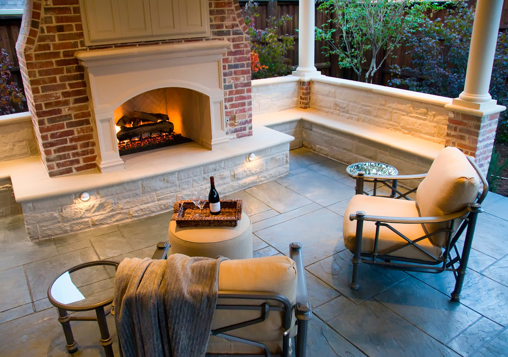 Mid-sized traditional backyard patio in Dallas with a fire feature, stamped concrete and a roof extension.