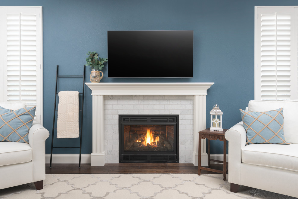 Family room - mid-sized traditional dark wood floor and brown floor family room idea in San Francisco with blue walls, a standard fireplace, a stone fireplace and a wall-mounted tv