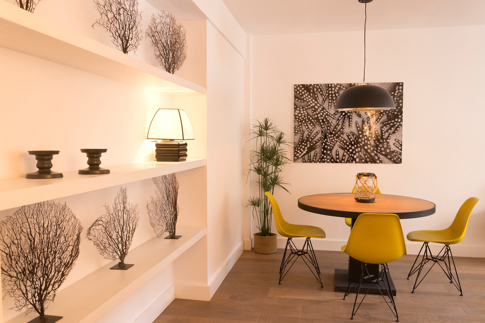 Ejemplo de comedor contemporáneo de tamaño medio abierto sin chimenea con paredes blancas y suelo de madera en tonos medios