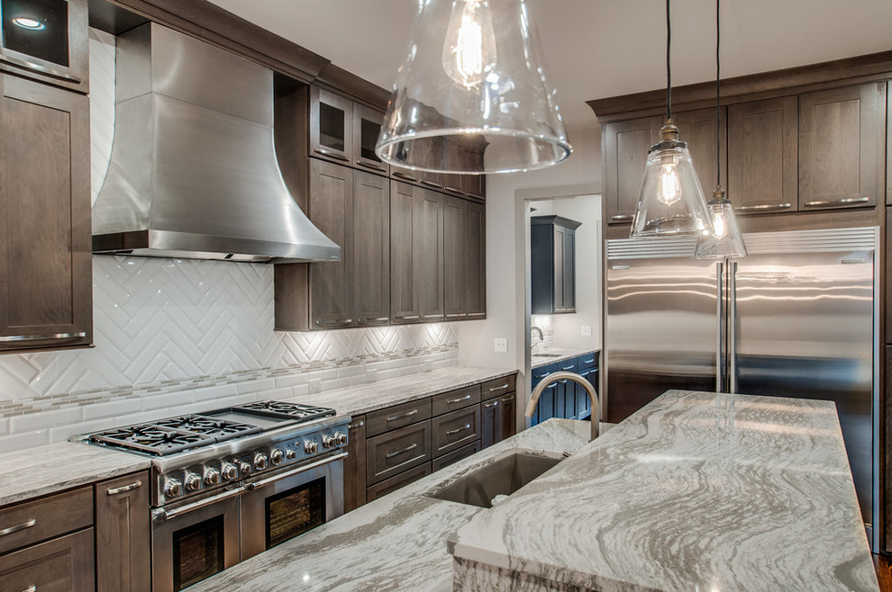 Inspiration for a mid-sized transitional l-shaped separate kitchen in Nashville with an undermount sink, shaker cabinets, dark wood cabinets, granite benchtops, white splashback, porcelain splashback, stainless steel appliances, dark hardwood floors, with island and brown floor.