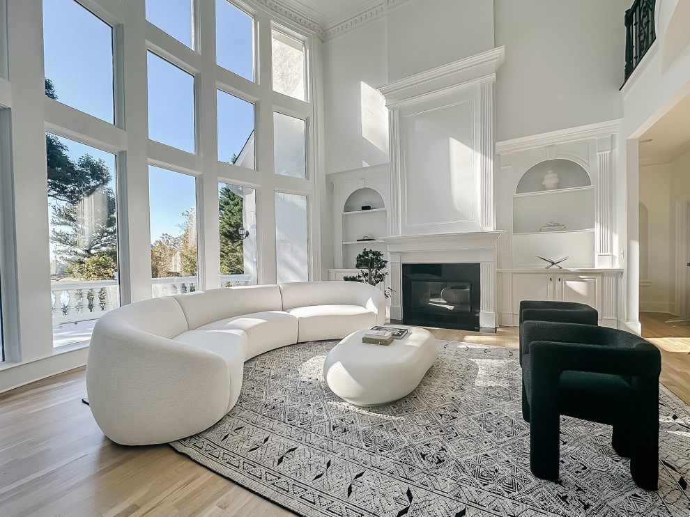 This is an example of an expansive modern formal open concept living room in Atlanta with white walls, light hardwood floors, a standard fireplace, a tile fireplace surround, no tv, brown floor and panelled walls.