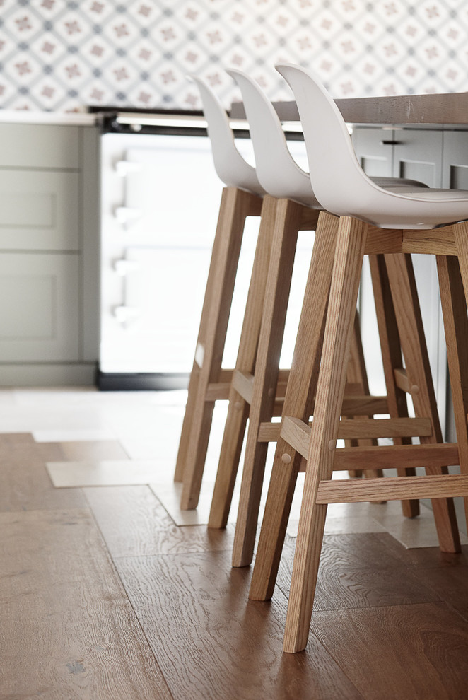 Exemple de cuisine américaine in L With un évier encastré, un placard à porte shaker, des portes de placard grises, un plan de travail en quartz modifié, une crédence multicolore, une crédence en carreau de ciment, un électroménager de couleur, un sol en bois brun, îlot, un sol beige and un plan de travail blanc.