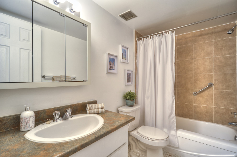 Inspiration för små moderna en-suite badrum, med släta luckor, skåp i ljust trä, ett badkar i en alkov, en dusch/badkar-kombination, en toalettstol med separat cisternkåpa, beige kakel, keramikplattor, vita väggar och mosaikgolv
