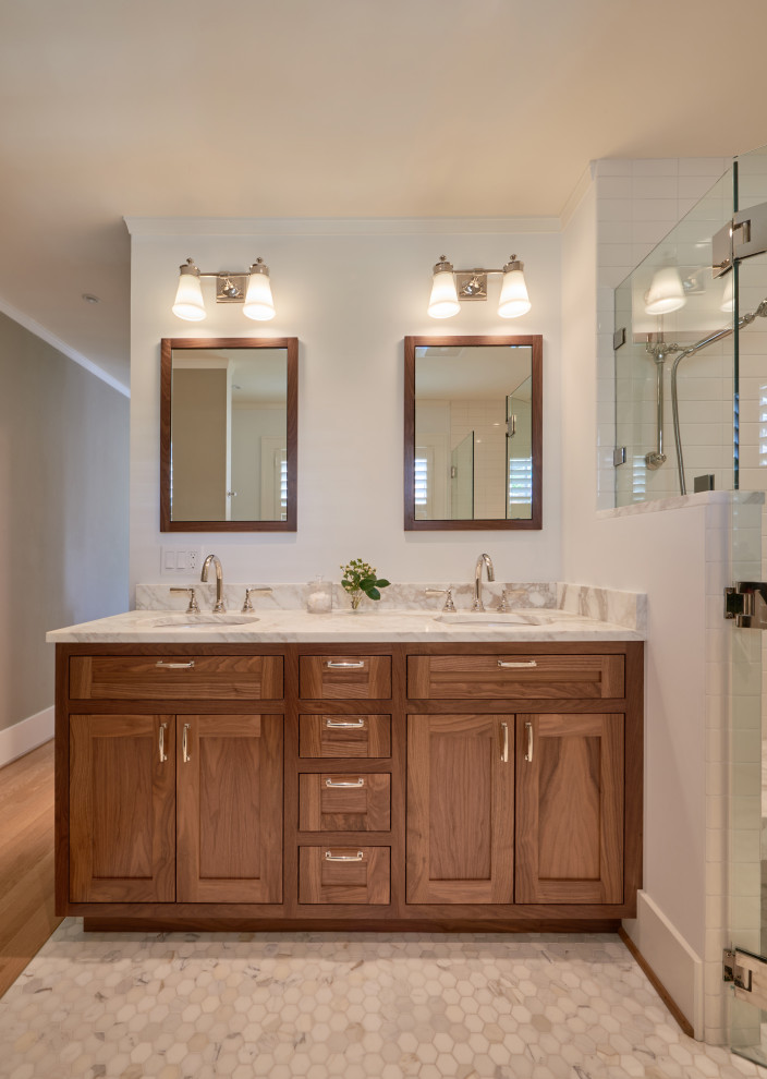 This is an example of a mid-sized transitional master bathroom in Seattle with shaker cabinets, medium wood cabinets, a curbless shower, a two-piece toilet, white tile, porcelain tile, blue walls, marble floors, an undermount sink, marble benchtops, white floor, a hinged shower door, multi-coloured benchtops, a shower seat, a double vanity and a built-in vanity.