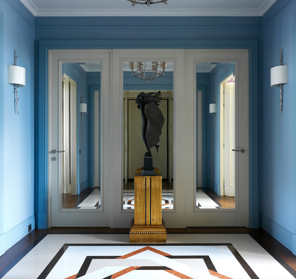 Photo of a mid-sized transitional foyer in Moscow with blue walls, marble floors and multi-coloured floor.