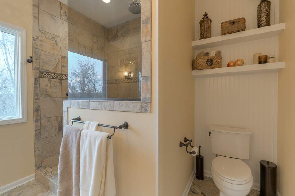 Example of a mid-sized transitional master multicolored tile ceramic tile doorless shower design with raised-panel cabinets, beige cabinets, a two-piece toilet, beige walls, an undermount sink and quartz countertops