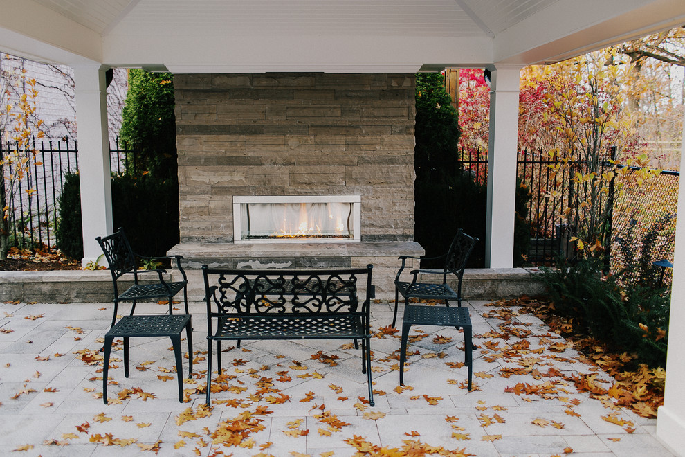 Photo of a mid-sized arts and crafts backyard patio in Toronto with a fire feature.