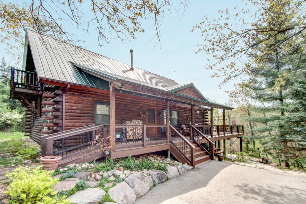 Inspiration for a huge rustic backyard deck remodel in Milwaukee with a roof extension